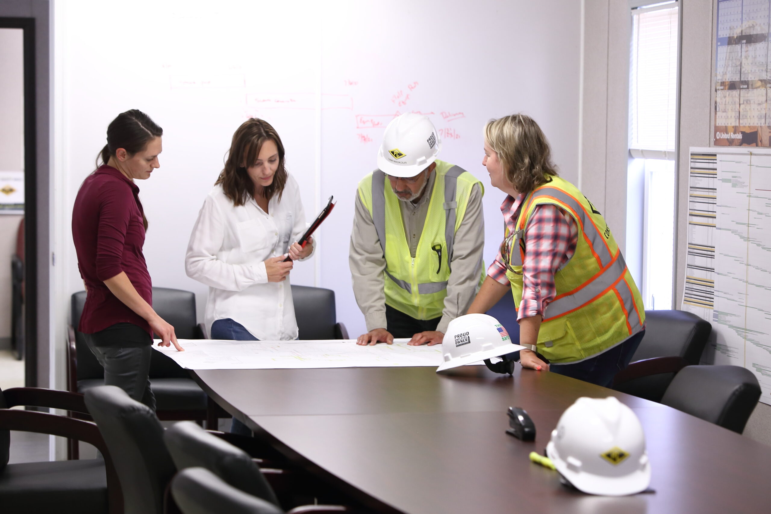 a man and 3 women in an office valuing kaizen and continuous improvement