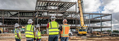 After receiving Lean learning for owners, an owner provides instruction to four construction workers on a job site.